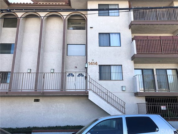 Front view of a multi-story building with balconies and exterior stairs.
