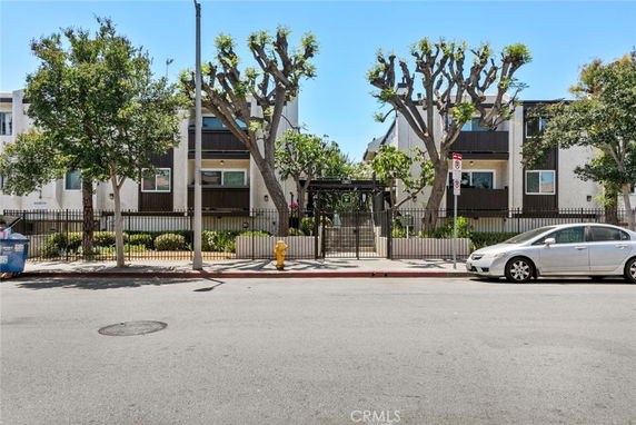 Front view of a residential building with two stories and a gated entrance.