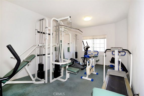 Room with various gym equipment for exercise.