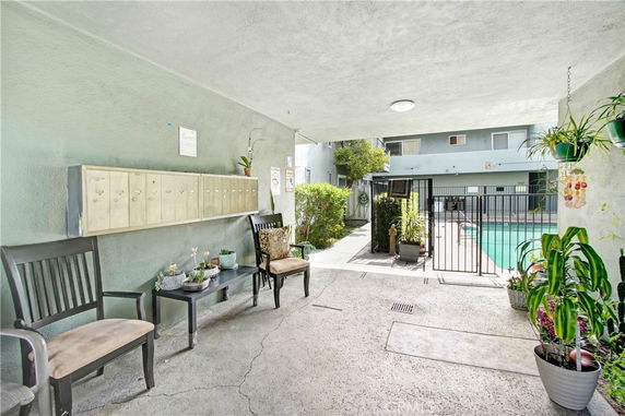 View of a swimming pool area with surrounding outdoor seating and mailbox section.
