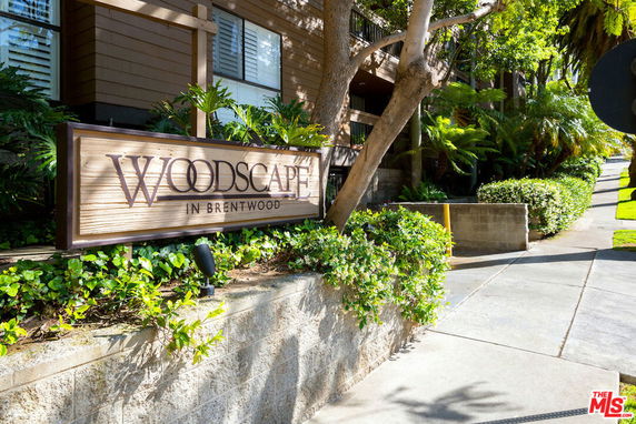Front view of a building with 'Woodscape in Brentwood' sign and surrounding greenery.