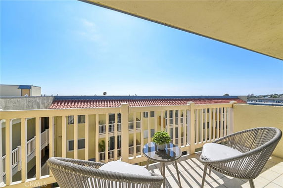 View from a balcony overlooking a tiled rooftop and distant scenery.