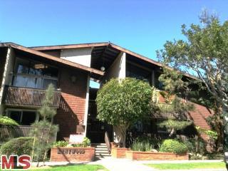 Front view of a multi-story building with balconies and angled roof.