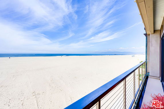Wide angle view of beach and ocean from a balcony.