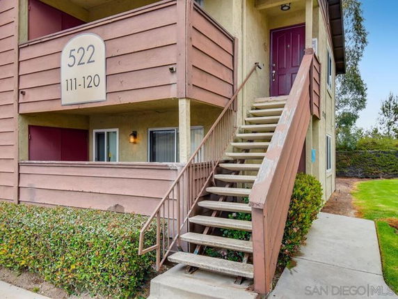 Front view of a two-story apartment building with an exterior staircase.