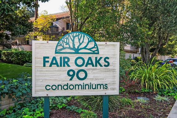 Front view of condominium building with a sign for Fair Oaks Condominiums.