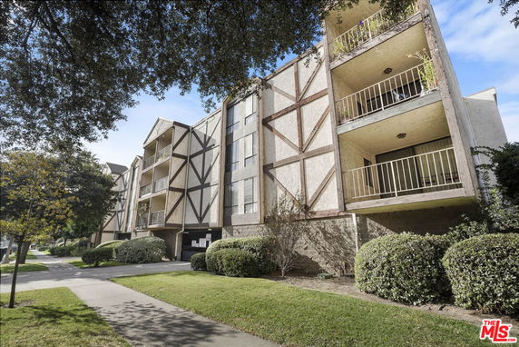 Front view of a multi-story apartment building with balconies.
