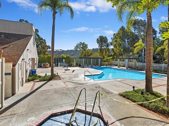 Outdoor swimming pool area with additional hot tub and surrounding trees.