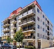 Front view of a multi-story apartment building with balconies.