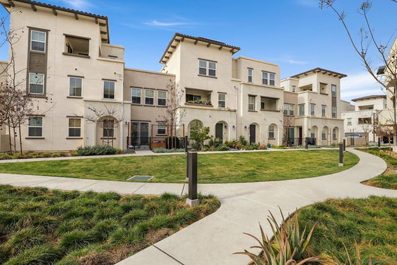 Front view of a modern multi-story apartment building with balconies.