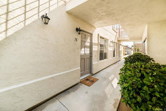 Front entrance of a building with a covered walkway and exterior door.