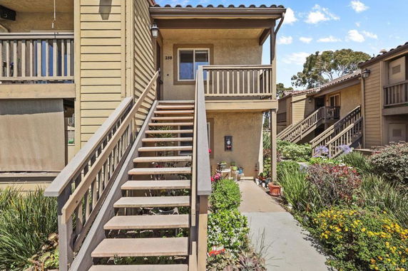 Front view of a residential building with a staircase leading to the entrance.