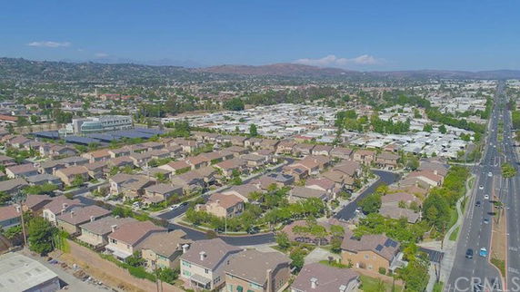 Panoramic view of a residential area with multiple houses and a road.