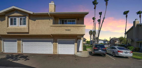 Front view of a two-story building with multiple garages and parking area.