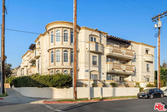 Front view of a multi-story apartment building with rounded corner windows and balconies.