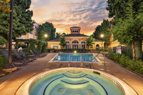 View of a swimming pool area with a building in the background.