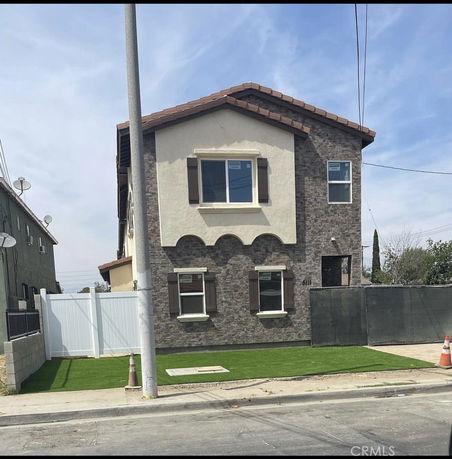Front view of a two-story house with brick and stucco exterior.