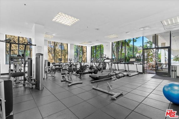 Indoor gym area with various exercise equipment and large windows.