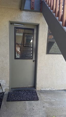 Exterior view of a door under a staircase.