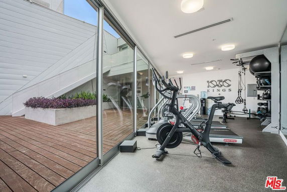 Indoor gym area with exercise equipment and glass walls.