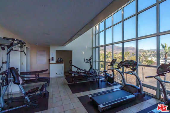 Indoor gym area with exercise equipment and large windows.