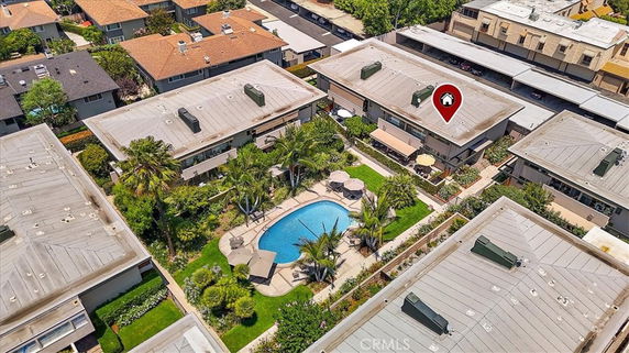 Aerial view of a residential area with a swimming pool surrounded by multiple buildings.