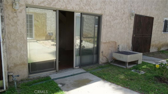 View of a house exterior with sliding glass doors and a metal door.