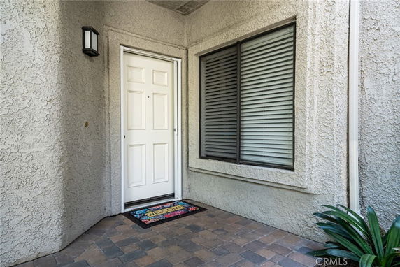 Front view of a house entrance with a door and a large window beside it.