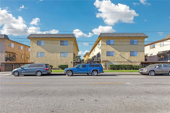Front view of a multi-story residential building with a sloped roof.