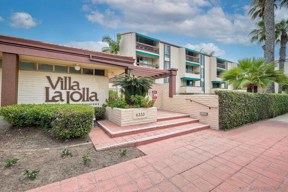 Front view of a multi-story condominium building with a sign reading 'Villa La Jolla'.