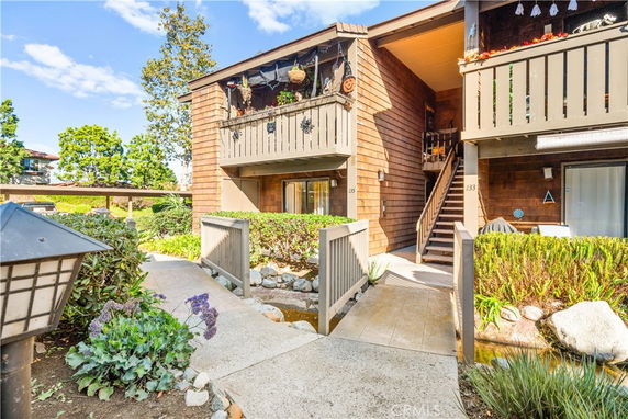 Front view of a multi-story residential building with wooden exterior and balconies.