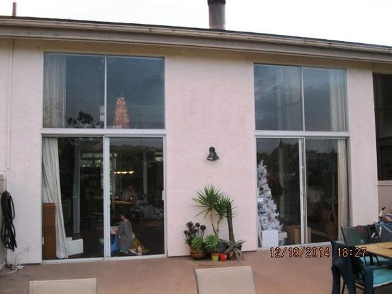 Front view of a house with large sliding glass doors and minimal decoration on a patio.