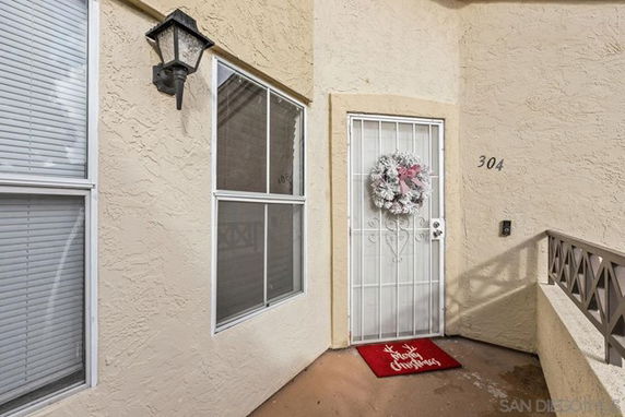 Front view of a house entrance with a security door and festive wreath.