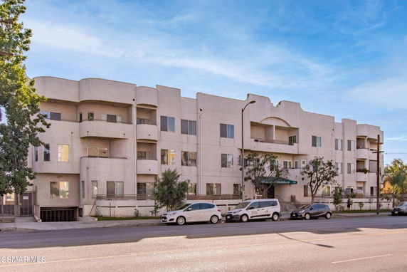 Front view of a multi-story apartment building with balconies.