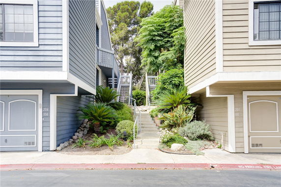 Front view of multi-story residential buildings with garages and stairway access.