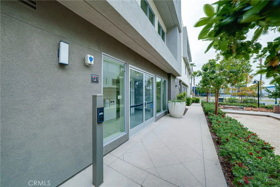 Front view of a modern building with glass windows and a pathway.