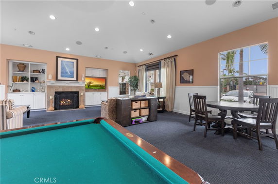 Indoor recreation room with a pool table and seating area.