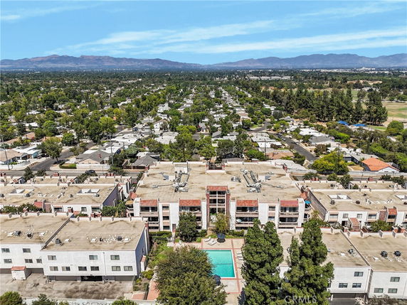 Wide aerial view of a residential area with multiple buildings and surrounding landscape.