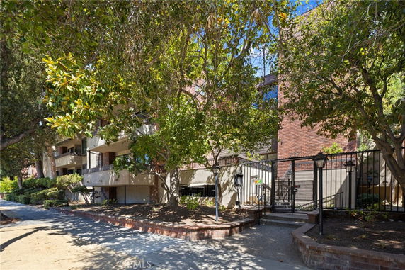 Front view of a multi-story building with balconies and brick facade.