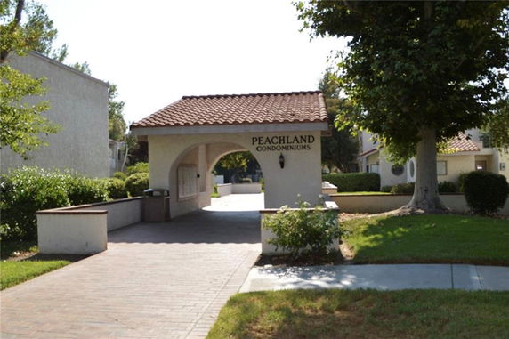 Front view of a condominium building entrance with a tiled roof.