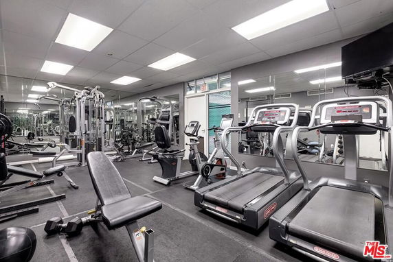 Indoor gym with various exercise equipment including treadmills and weight machines.