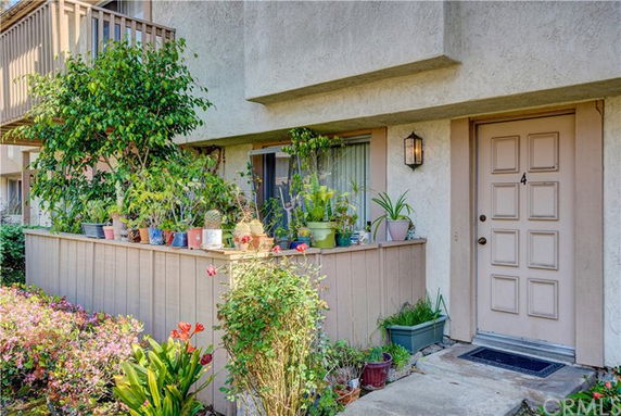 Front view of a residential unit with a small garden area at the entrance.