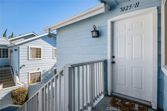 Front view of a residential building with a white door and light blue siding.