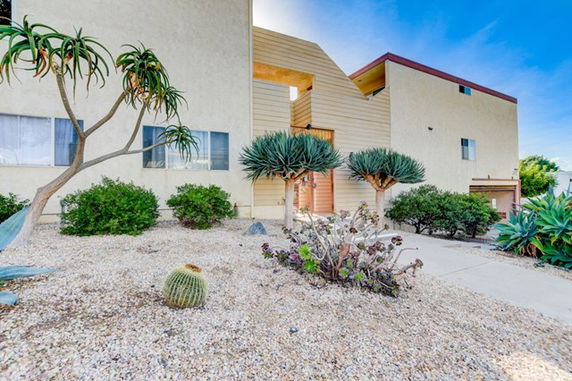 Front view of a two-story house with modern design and xeriscape landscaping.