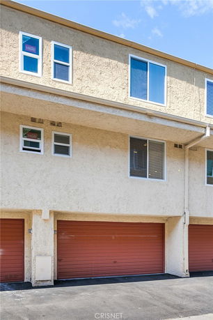 Front view of a multi-story building with a garage.