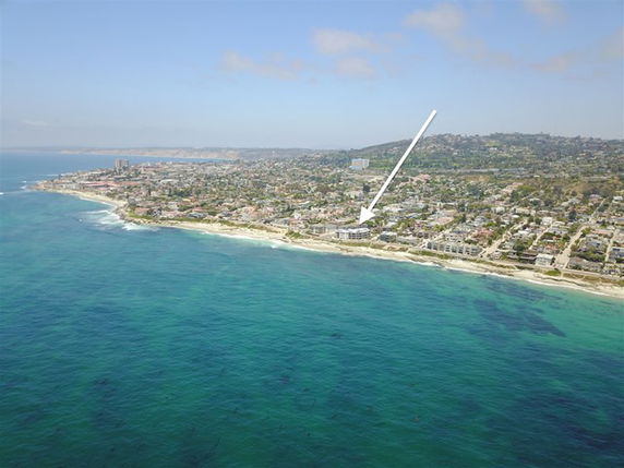 Panoramic view of a coastal area with buildings along the shoreline.