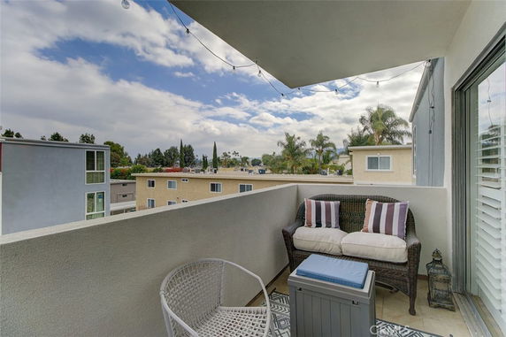 Balcony view overlooking residential buildings and sky.