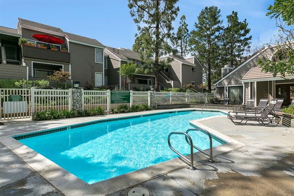 Outdoor swimming pool area with adjacent residential buildings.
