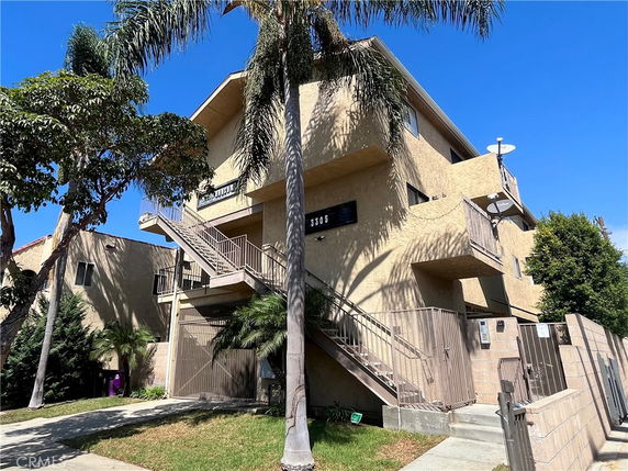 Front view of a multi-story building with exterior stairs and balconies.