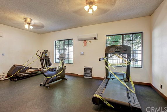 Indoor gym area with exercise equipment and yellow safety tape.